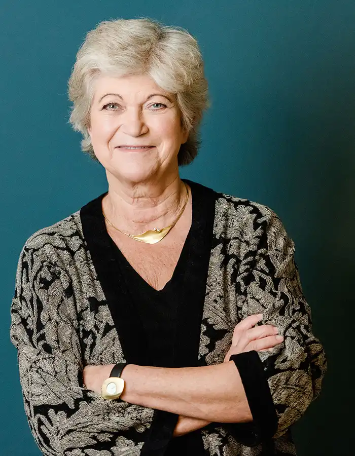Barbara Jaeschke, lächelnd in einer gemusterten Strickjacke und Goldschmuck, posiert für ein Interview auf Unternehmensnachfolge.