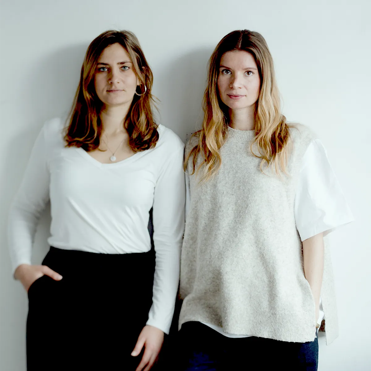 Zwei Frauen, die Gründerinnen der Pflege-App fabel, stehen Seite an Seite vor weißem Hintergrund.