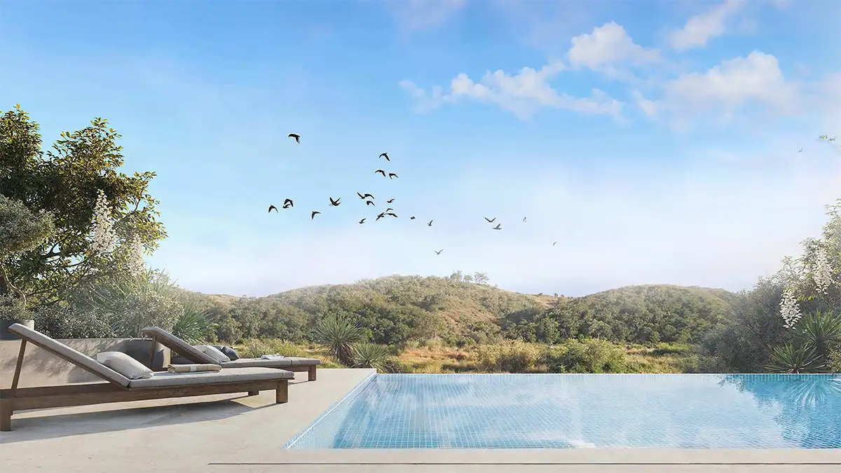 Modulares-Wohnprojekt-Portugal-Urban-Cell_Pool Infinity-Pool mit zwei Liegestühlen mit Blick auf grüne Hügel unter einem blauen Himmel mit Vögeln fliegen über.