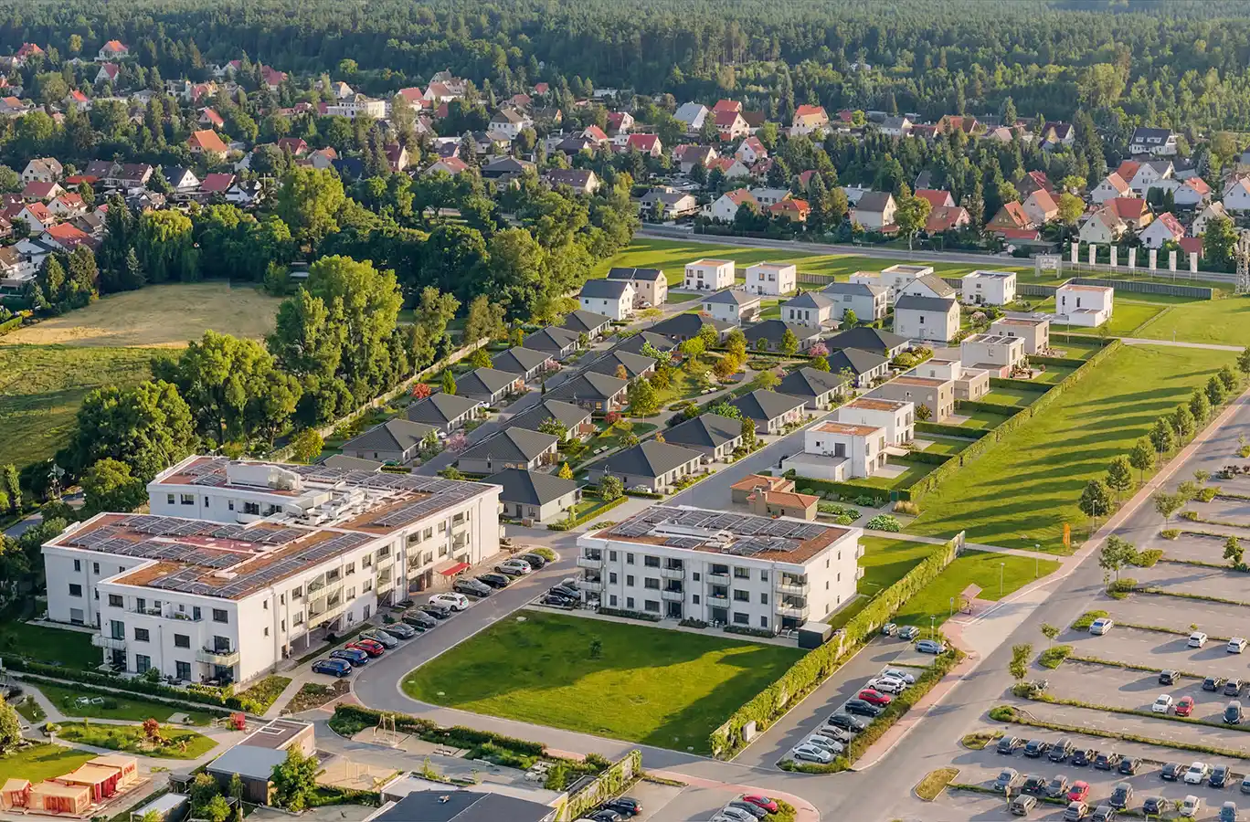 Seniorenwohnanlage-Grosspoesna-2 Luftaufnahme eines Vorortviertels mit Häusern, Mehrfamilienhäusern und geparkten Autos.