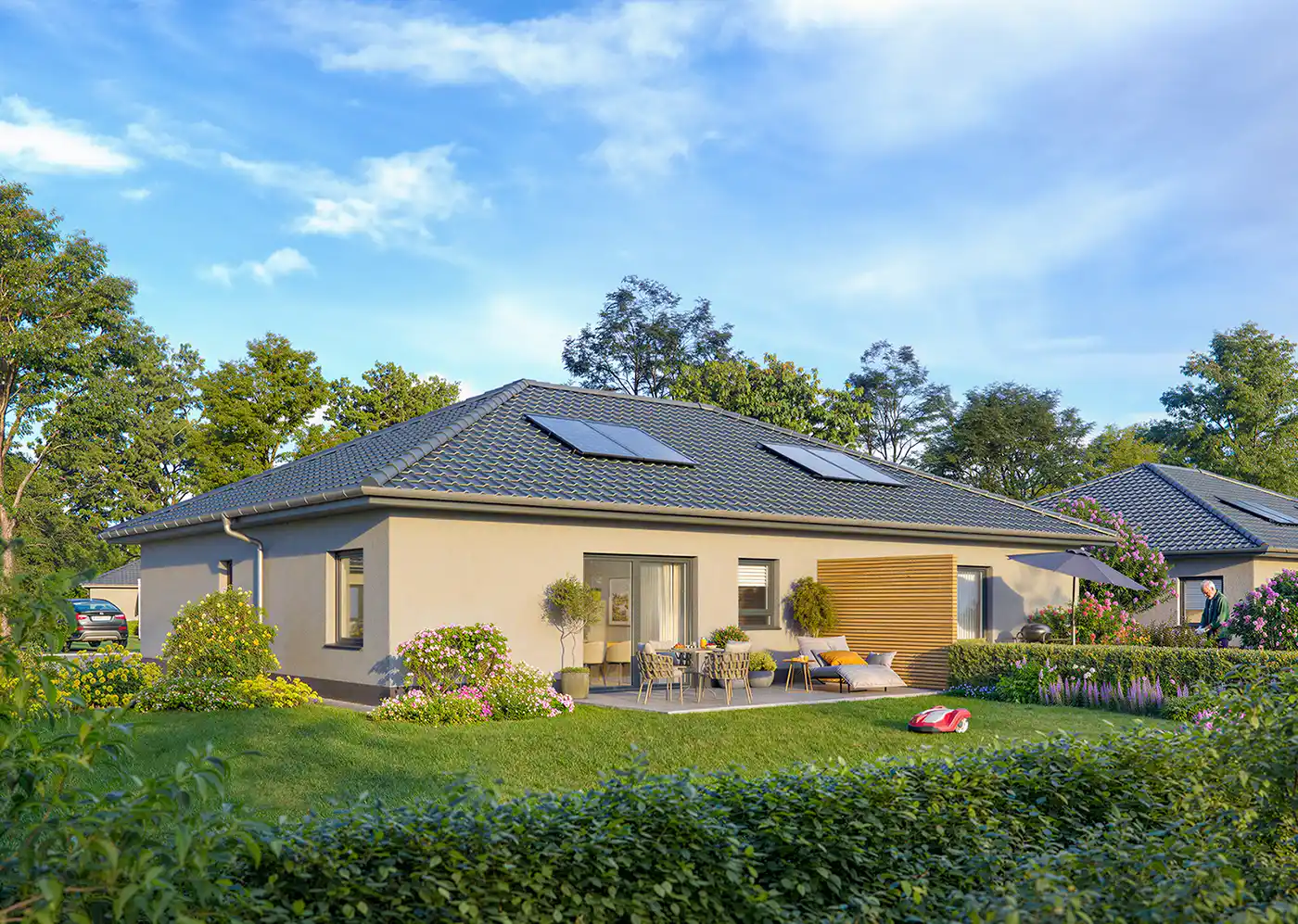 Seniorenwohnanlage-Grosspoesna-Haus-B-Garten Modernes einstöckiges Haus mit Terrasse, Garten, Rasenfläche und Gartenmöbeln unter blauem Himmel.