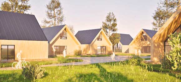 Gutleben-Buettnersdorf-Haus-Planung Moderne Holzhäuser mit schwarzen Dächern, die um einen begrünten Innenhof mit Bäumen und Spazierwegen angeordnet sind.